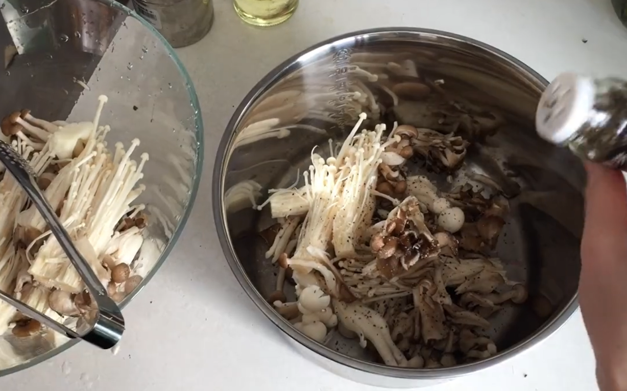 2.將菇類平均堆疊一層，撒上黑胡椒粒、食用油、鹽巴後再將菇堆疊一層後灑上調味料，動作重複層層堆疊。